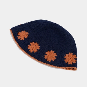 Detail of handcrafted navy blue crochet bucket hat with orange floral patterns