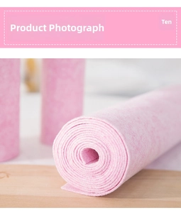 Close-up of pink textured coconut fiber dishcloth roll on a natural wooden background