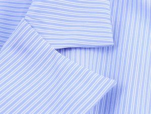 Close-up of blue and white fine pinstripe cotton fabric texture and shirt collar fold