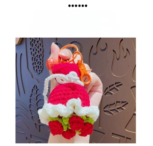 Detailed handmade crochet flower keychain with red strawberry charm and orange clasp accessory