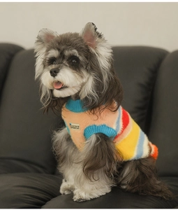 Close-up of rainbow striped pet sweater with thick faux fur texture and brand patch
