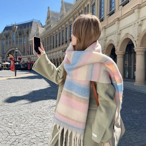 Colorful striped scarf with fringes in pink and blue, modeled on a European city square