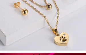 Détail macro du pendentif cœur doré avec empreinte de patte et pierre de zircon brillant