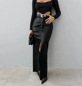 Detail of high-waist leather skirt with front slit and belt with silver buckle