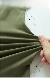 Vue macro du tissu vert armée haute élasticité montrant l'extensibilité et densité