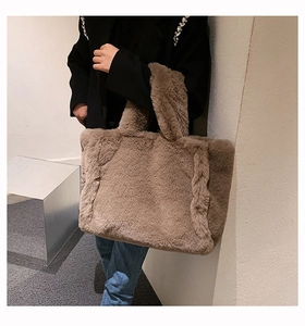 Détail d'un grand sac cabas en fausse fourrure marron avec texture douce et anses assorties