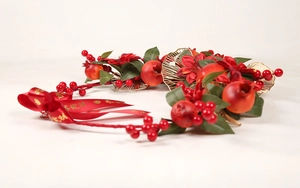 Détails de baies rouges, feuilles dorées et ruban festif sur une couronne du Nouvel An
