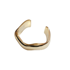 Bracciale rigido dorato con design a onde e finitura lucida su sfondo bianco neutro
