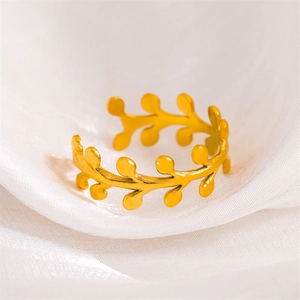 Elegant gold olive leaf stainless steel adjustable ring on white silk fabric