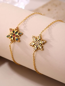 Dettaglio dei bracciali a fiocco di neve dorati con zirconi colorati e trasparenti