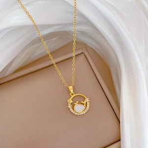 Close-up of gold titanium necklace with shell pendant on elegant white silk background