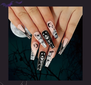 Detailed view of Halloween coffin nails featuring skull and pumpkin art on model hand