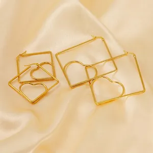Golden heart geometric stud earrings in square frames set on a champagne silk background