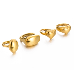Detailed view of four polished gold stainless steel rings in heart and geometric shapes