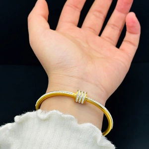 Dettaglio del bracciale in titanio placcato oro rosa con tre anelli rotanti con diamanti