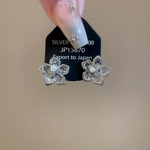 Detail der silbernen Blumenohrstecker mit hohlen Blütenblättern, Zirkonia und weißer Perle
