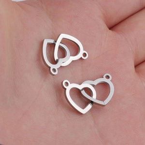 Macro view of interlocking heart stainless steel connectors held in hand for size scale
