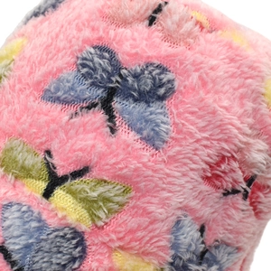 Vue macro d'un tissu peluche rose avec motifs papillons bleus et jaunes pour bonnets d'hiver
