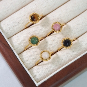 Detailed set of 5 gold-finish rings with colorful natural stones in a wooden display box