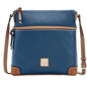 Detail of dark blue pebble leather crossbody bag with brown trim and gold hardware