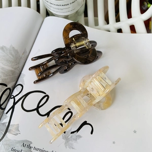 Close-up of tortoise shell and marble acetate butterfly hair claws for elegant styling