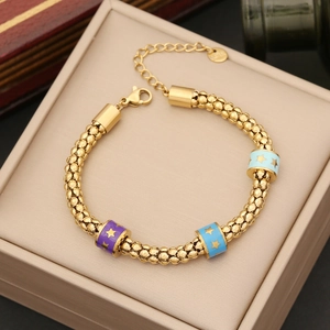 Dettaglio macro del bracciale dorato con perline stella smaltate e chiusura a moschettone
