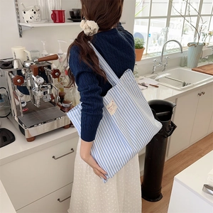 Detail of blue and white striped canvas tote bag with reinforced wide shoulder strap