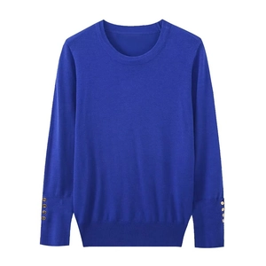 Close-up of royal blue knitted sweater sleeves featuring decorative gold buttons and ribbed cuffs
