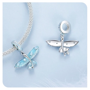 Macro detail of S925 sterling silver flying fish charm with blue opal and enamel