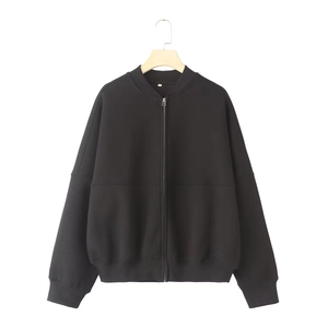 Detail of classic black zip-up bomber jacket with ribbed collar and cuffs on wood hanger