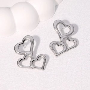 Detailed view of silver heart-shaped hollow earrings with layered minimalist design