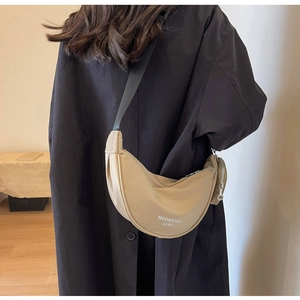 Dettaglio borsa a tracolla a mezzaluna in nylon beige con logo e piccolo borsellino