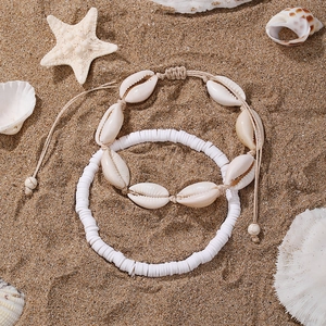 Detail of beach style anklet set with white shells and irregular beads on sand