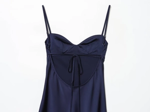 Detail of satin slip dress with thin straps and lace-up back design in navy blue