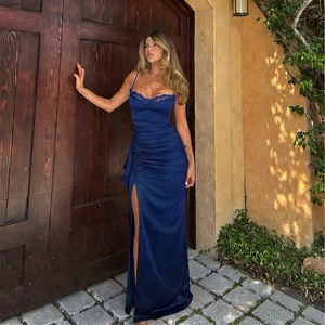 Détail d'une robe de soirée en satin bleu marine avec dentelle et fente latérale