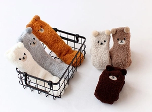 Gros plan de chaussettes en polaire corail avec oreilles d'ours 3D et peluche