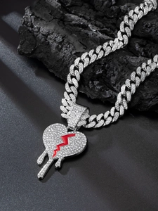 Silver Cuban link necklace with iced out bleeding heart pendant on dark charcoal background