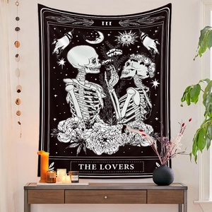 Detail of The Lovers tarot tapestry with skull and flower patterns on a white wall