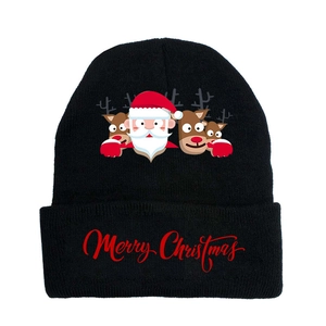 Detail of knitted winter beanie featuring red Merry Christmas text and festive patterns