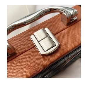Detail of creative radio box bag featuring Saffiano leather texture and silver metal handle