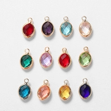Macro shot of twelve multicolor oval birthstone charms with polished golden frames