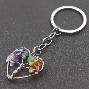 Macro view of silver tree of life heart keychain featuring colorful natural crystal stones