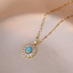 Gold necklace with flower pendant featuring a blue turquoise stone and sparkling zircons