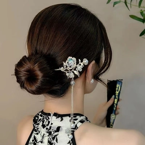 Detail of silver magnolia hair stick with pearl tassels worn in an elegant updo hairstyle