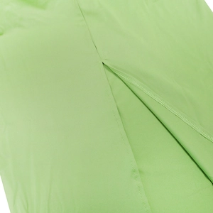 Detail of side slit and precision stitching on a slim green halter maxi dress