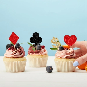 Glittery poker-themed cupcake toppers featuring card suits and dollar signs for casino parties