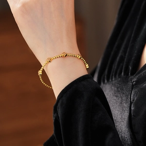 Primo piano del bracciale a quadrifoglio placcato oro 18k con dettagli di perline sul polso