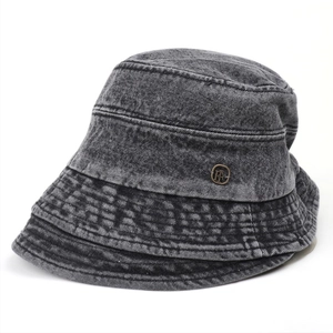 Close-up of deep gray washed denim bucket hat featuring a vintage bronze metal badge