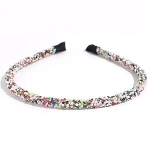 Détail de strass colorés et perles d'imitation sur un serre-tête fin en cristal