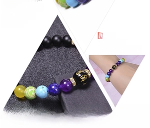Detail view of seven chakra natural stone beads with engraved mantra and diamond accents